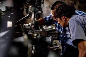 asiatisch Arbeiter im Produktion Pflanze Bohren beim Maschine. Fachmann Arbeiter in der Nähe von Bohren Maschine auf Fabrik. Fertigstellung Metall Arbeiten intern Stahl Oberfläche auf Drehbank Schleifer Maschine mit fliegend Funken. foto