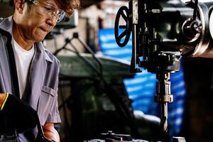 Ingenieur Arbeiter im Produktion Pflanze Bohren beim Maschine. Fachmann Arbeiter in der Nähe von Bohren Maschine auf Fabrik. Mann inspizieren und reparieren Maschine zum Betrieb im Werkstatt. foto