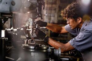 asiatisch Arbeiter im Produktion Pflanze Bohren beim Maschine. Fachmann Arbeiter in der Nähe von Bohren Maschine auf Fabrik. Fertigstellung Metall Arbeiten intern Stahl Oberfläche auf Drehbank Schleifer Maschine mit fliegend Funken. foto