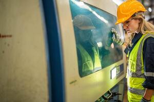 Fabrik Ingenieur Frau Stehen Vertrauen zu Steuerung Panel schalten. Arbeiter funktioniert beim schwer Maschine beim Industrie Fabrik. mit Maschinen Ausrüstung Pflanze Technologie. Clever Industrie Arbeiter Betriebs. foto