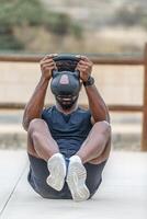 anonym Sportler im Activewear tun Abs trainieren mit Kettlebell foto