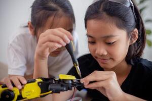 erfinderisch Kinder lernen beim Zuhause durch Codierung Roboter Autos und elektronisch Tafel Kabel im Stengel. konstruieren Roboter Autos beim Zuhause foto