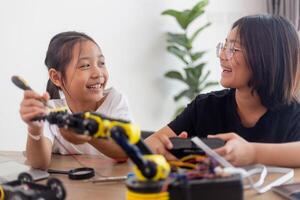 erfinderisch Kinder lernen beim Zuhause durch Codierung Roboter Autos und elektronisch Tafel Kabel im Stengel. konstruieren Roboter Autos beim Zuhause foto