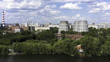 Antenne Aussicht von ein groß modern Stadt und das Teich. Video. fliegend Über das Sommer- Wasser Reservoir in der Nähe von industriell Kreis von das Stadt mit Schornsteine und viele Grün Bäume auf Blau wolkig Himmel Hintergrund. foto