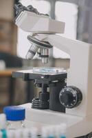 biochemisches wissenschaftlerteam, das mit einem mikroskop für die entwicklung von coronavirus-impfstoffen im pharmazeutischen forschungslabor arbeitet, selektiver fokus foto