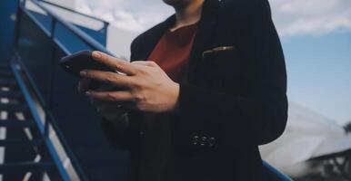 jung asiatisch Frau im International Flughafen, mit Handy, Mobiltelefon Smartphone und Überprüfung Flug beim das Flug Information Tafel foto