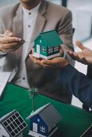 Immobilienmakler liefert dem Kunden ein Muster eines Musterhauses, Hypothekendarlehensvertrag, Leasing und Kauf und Verkauf von Haus- und Wohnungsversicherungs-Hypothekendarlehenskonzept foto
