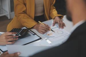 finanzanalysten analysieren während einer diskussion auf einem unternehmenstreffen geschäftsfinanzberichte zu einem investitionsprojekt zur planung digitaler tabletten und zeigen die ergebnisse ihrer erfolgreichen teamarbeit. foto