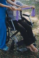 jung Krankenschwester oder Physiotherapeut im Peelings Portion ein glücklich im Ruhestand alt Frau tun Fitness Übungen mit Licht Gewicht Hanteln beim heim. Konzept von Physiotherapie zum Senioren foto