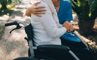 ein Krankenschwester nehmen Pflege ein Senior männlich auf Rollstuhl im seine Garten beim Zuhause foto