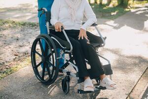 Krankenschwester mit Alten Mann im Rollstuhl beim Park foto