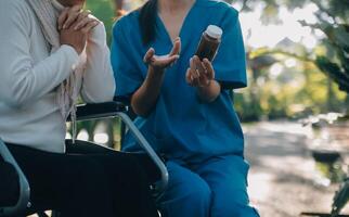 Krankenschwester mit Alten Mann im Rollstuhl beim Park foto