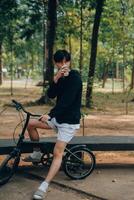 gut aussehend glücklich jung Mann mit Fahrrad auf ein Stadt Straße, aktiv Lebensstil, Menschen Konzept foto