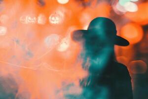 ai generiert Silhouette von ein Mann im ein Hut und Rauch auf ein Hintergrund von farbig Beleuchtung. foto