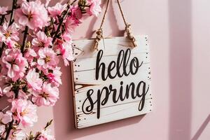 ai generiert Hallo Frühling Botschaft auf hölzern Zeichen hängend auf Rosa Mauer mit Kirsche Blüten foto