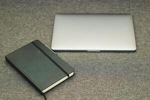 Laptop Serie eben Metall auf das Tabelle mit ein Geschäft Tagebuch foto