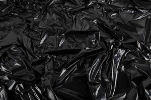 Full Frame abstrakter Hintergrund aus zerknitterter schwarzer Plastikfolie foto