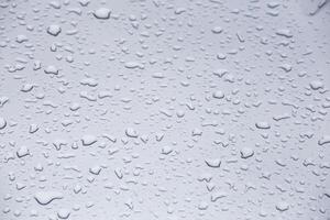 Wassertropfen auf grauer Glasoberfläche, Vollbild-Nahaufnahmehintergrund mit selektivem Fokus foto