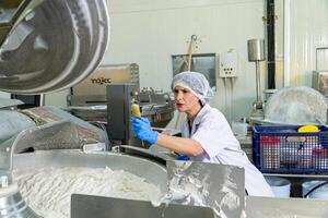 Kaukasus Frau Arbeiten im ein Essen Fabrik tragen schützend Kleider und Handschuhe. foto