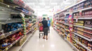 Menschen Gehen wählen Produkte im das Supermarkt verwischen. foto