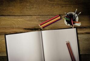 Farbe Bleistift und Skizzenbuch auf Holz Tabelle foto