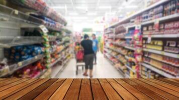 hölzern Planke und Menschen Gehen wählen Produkte im das Supermarkt verwischen. foto