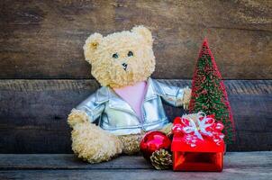 Teddy Bär und Geschenk auf hölzern Hintergrund foto