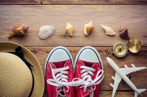 Kleidung und Zubehör zum Sommer- Reise Ausflug auf Holz Fußboden foto
