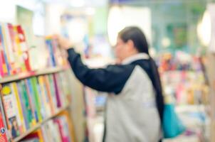 konzentriert verwischen Bild von ein Buchhandlung mit Kunden lesen und suchen zum Bücher. Buchhandlung Hintergrund. foto