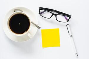 Kaffee Tasse, Stift, Notizbuch Clever Telefon und Brille auf Weiß Hintergrund foto