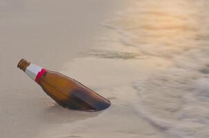 Flaschen sind links auf das Strand und werden Müll. foto