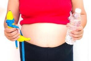 das Konzept von Diät zum Gewicht Verlust - - Fett Frauen im Hand haben Obst und Wasser. foto