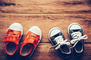 Schuhe zum Kinder auf hölzern Fußboden - - Lebensstil foto