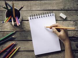 Hand Zeichnung, skizzieren Papier und bunt Bleistifte auf alt hölzern Hintergrund foto