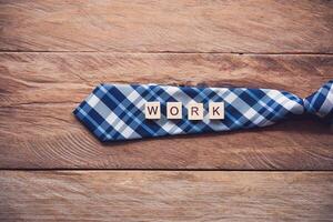 Krawatte und das Botschaft Arbeit stellen auf hölzern Fußboden - - Konzept von Lebensstil zum Geschäftsmann. foto