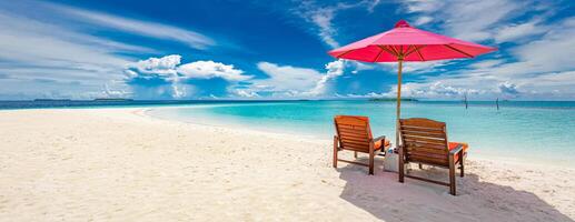 schön tropisch Strand Landschaft. Sonne Betten, Liegen, Regenschirm unter Palme Baum. Weiß Sand, Meer Aussicht mit Horizont, bunt Sonnenschein Himmel, Ruhe und Entspannung. inspirierend Strand Resort Hotel foto