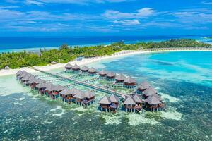 Schönes Malediven-Paradies. tropische luftreiselandschaft, seelandschaft mit holzbrücke, wasservillen, erstaunlicher meeressandhimmelstrand, tropische inselnatur. exotisches tourismusziel sommerferien foto