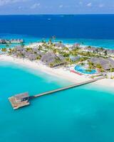 schöne luftaufnahme des pools und des strandes des resorts mit holzsteg. luxuriöse tropische Strandlandschaft, Schwimmen, Liegestühle und Liegen, Sonnenschirme. tropischer strand, draufsicht der luftdrohne foto