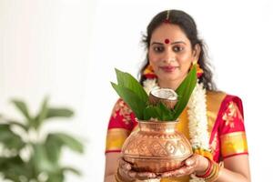 ai generiert traditionell indisch Marathi Frau halten ein Kupfer Kalash Kokosnuss Mango Blatt und Blumen- Dekoration, gudi Padwa Dekoration Bild foto