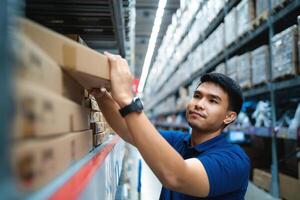 Arbeiter im Blau Uniform glücklich Arbeitskräfte im das Verteilung Center. liefern Kette und logistisch Netzwerk Technologie Konzept. foto