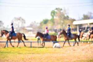 verschwommen Bilder von Menschen Reiten Pferde auf das trainieren Feld foto