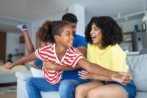 liebend vielfältig Eltern verbringen Zeit mit wenig bezaubernd Tochter haben Spaß zusammen beim modern Zuhause lächelnd Lachen, schließen hoch. glücklich multiethnisch Familie Konzept foto