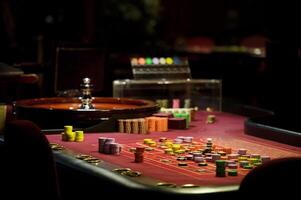 Nahansicht Chips und Roulette beim das Kasino auf das rot Tabelle foto