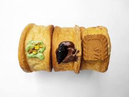 Cromboloni, Neu York rollen Croissant mit ein Vielfalt von Soße Beläge, isoliert Weiß Hintergrund. foto