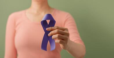 Krebs Bewusstsein Kampagne Konzept. global Gesundheitspflege. Welt Krebs Tag. schließen oben von ein jung weiblich bringt ein violett Band in das Vorderseite. foto