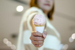 asiatisch Frau halten Erdbeere Joghurt Eis Sahne Kegel. Valentinstag Tag foto