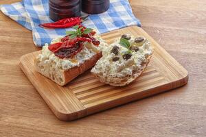 Bruschetta mit Weichkäse, Kapern und Tomate foto