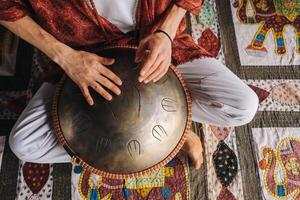 Nahansicht von ein des Mannes Hand spielen ein modern Musical Instrument, das Orion Schilf Trommel foto