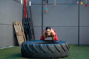 sportlich Frau umdrehen ein enorm Rad im das Fitnessstudio foto