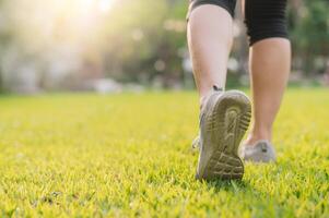 Jogger Frau. schließen oben Person Ausbildung Sport Läufer jung weiblich Schuh auf Gräser im Öffentlichkeit Park. Fitness Bein und Fuß Übung Athlet. Marathon- im Natur. aktiv gesund Lebensstil trainieren Konzept. foto